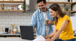 Man and woman in kitchen with laptop
