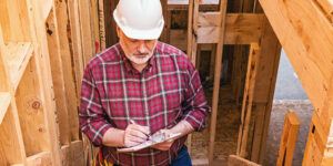 Man with a clipboard at a construction site